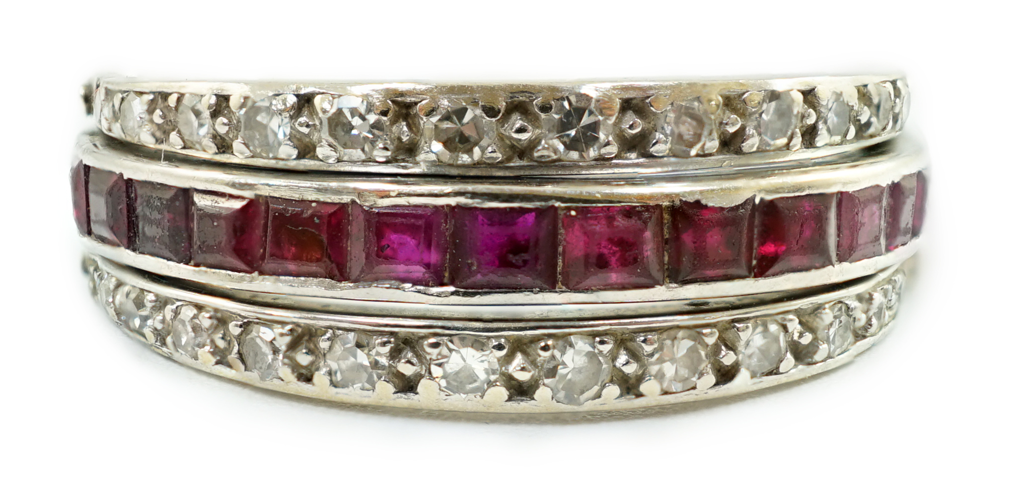 A mid 20th century white gold, diamond, ruby and sapphire set swivelling triple band eternity ring